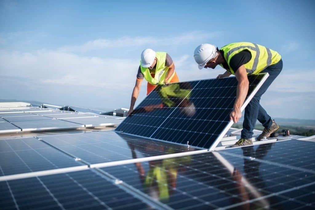 To autoriserede teknikere fra Zolenergi monterer solcellepaneler på et tag