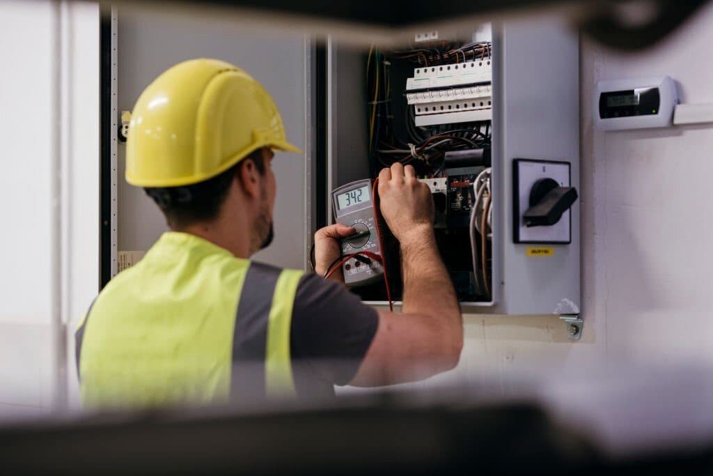 Autoriseret tekniker måler på en eltavle med multimeter
